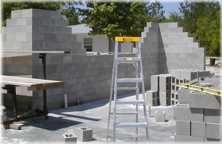 A picture of a partially stacked concrete block wall